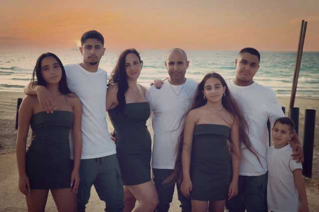 משפחה מצולמת על רקע שקיעה בים