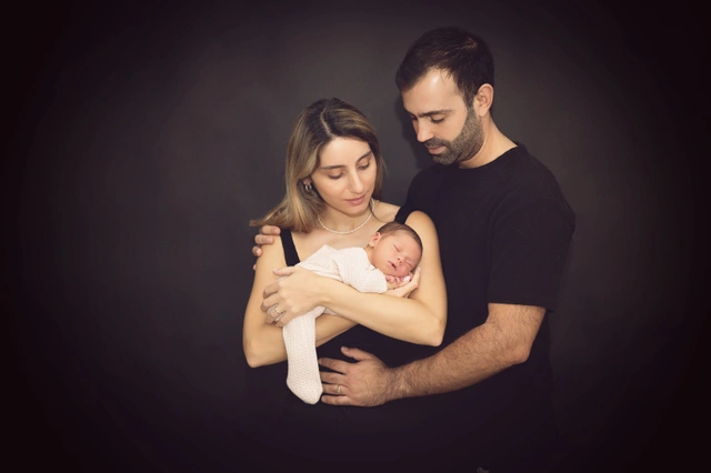 הורים מחבקים תינוק שזה עתה נולד
