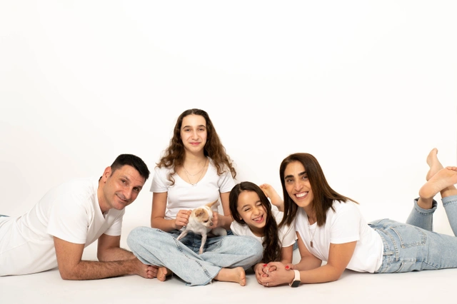 צילום משפחתי בסטודיו עם כלב מחייך