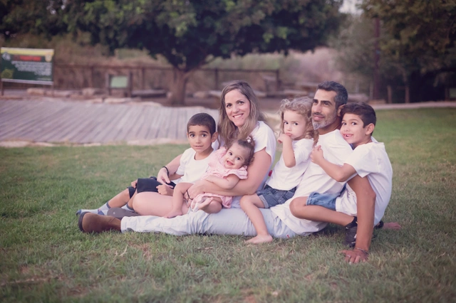 משפחה יושבת על הדשא בחוץ.